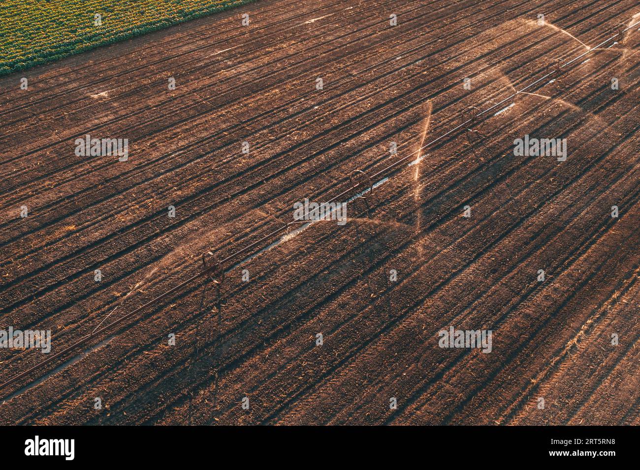 Arroseurs d'irrigation à roues agricoles en champ cultivé, prise de vue aérienne du drone pov de matériel agricole, vue à grand angle Banque D'Images