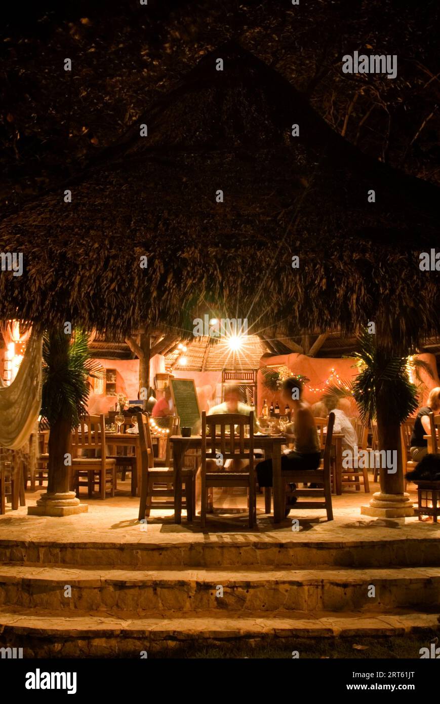 Restaurant au toit de chaume éclairé la nuit à Natura Cabanas, République dominicaine Banque D'Images