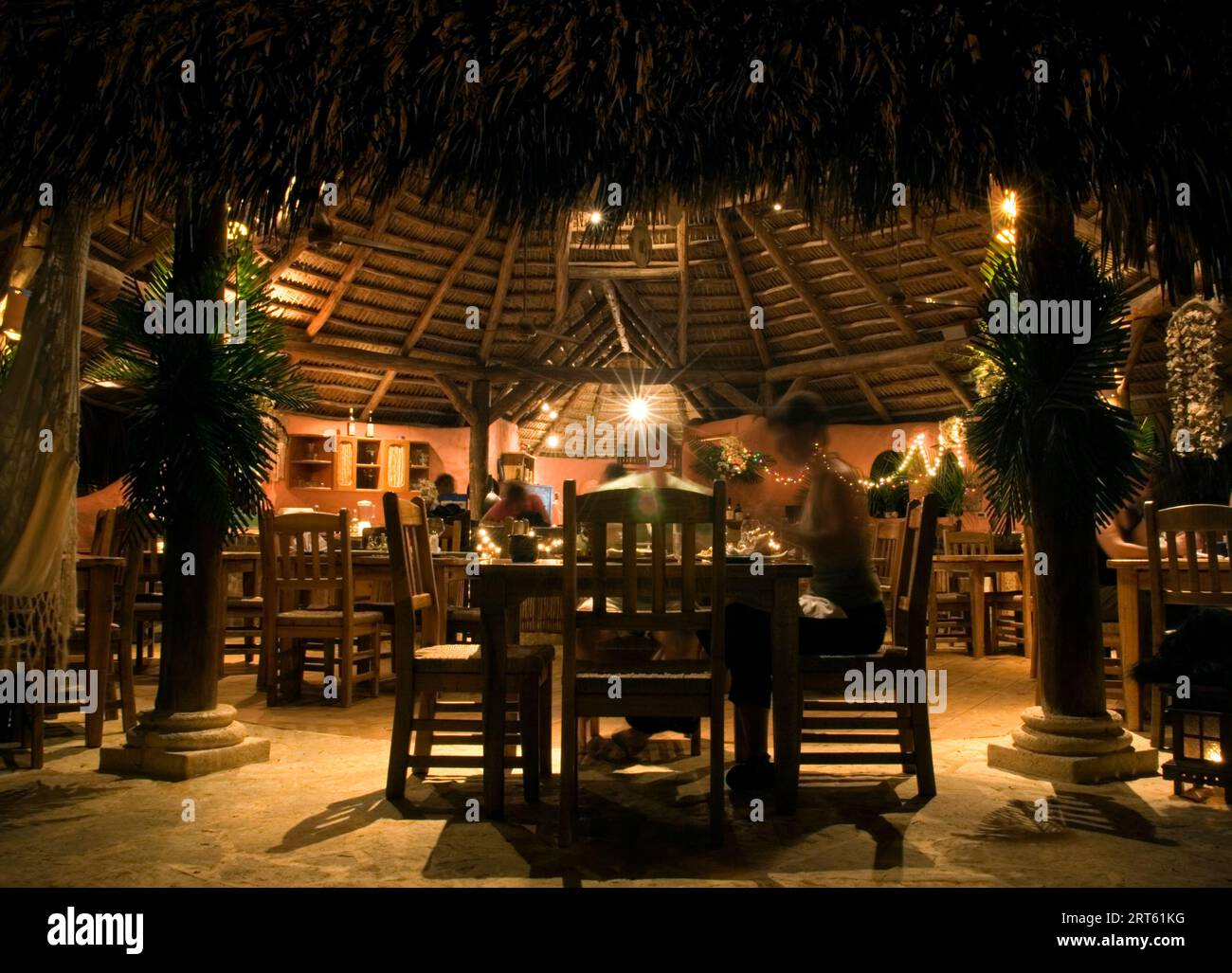 Restaurant au toit de chaume éclairé la nuit à Natura Cabanas, République dominicaine Banque D'Images