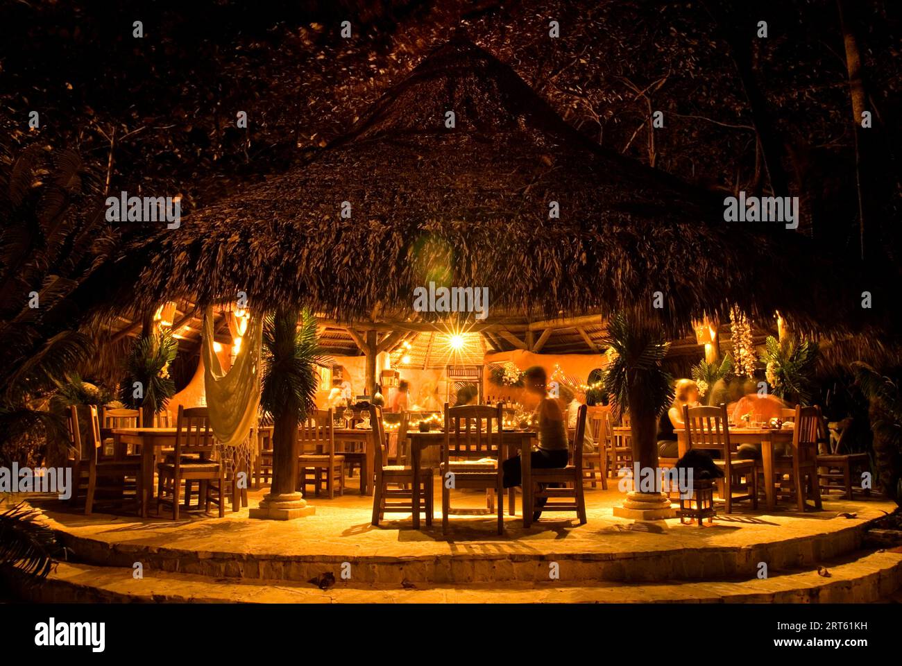 Restaurant au toit de chaume avec lueur chaude la nuit, République dominicaine. Banque D'Images