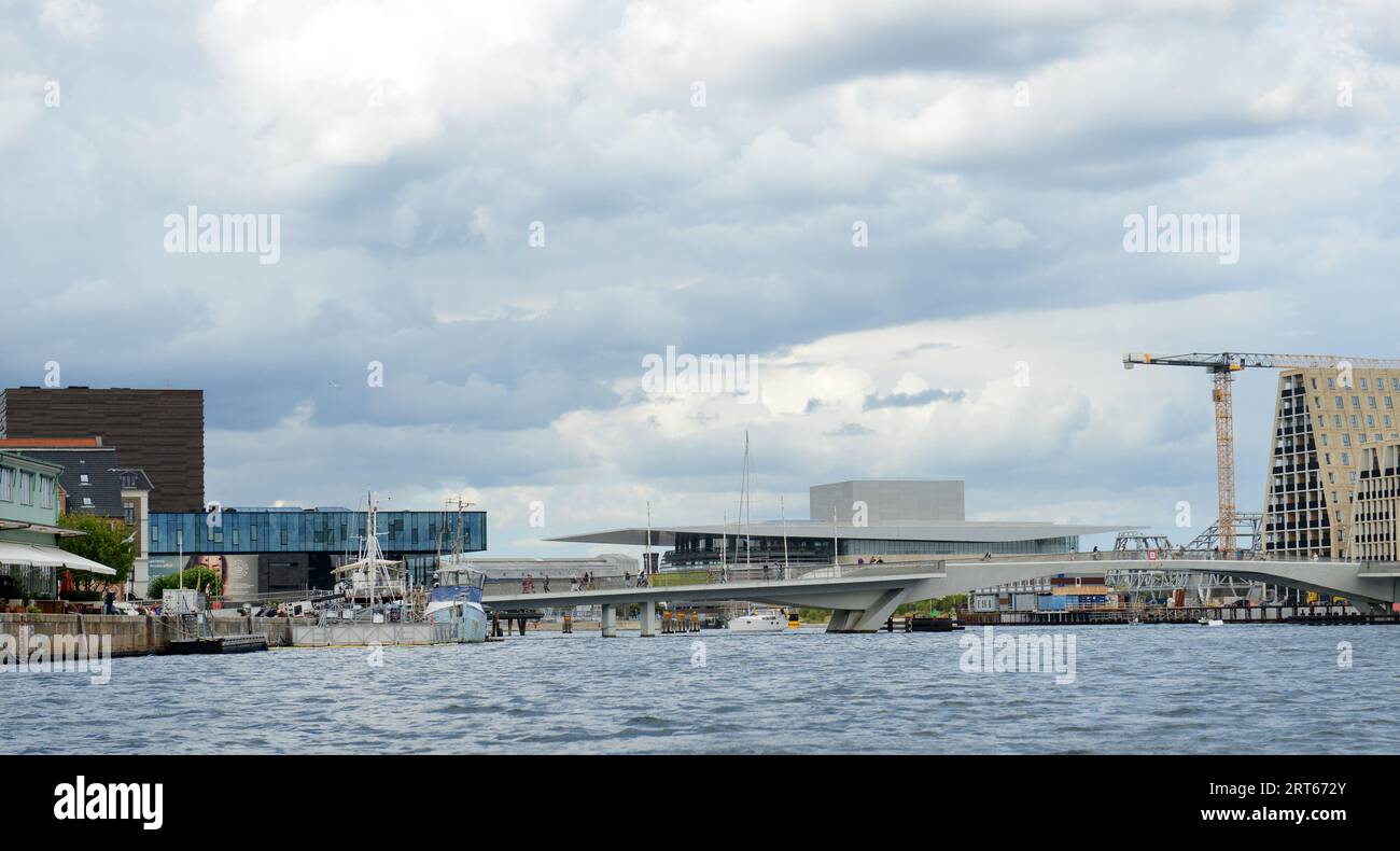 Une vue sur le pont piétonnier moderne Inderhavnsbroen et l'opéra moderne derrière à Copenhague, Danemark. Banque D'Images