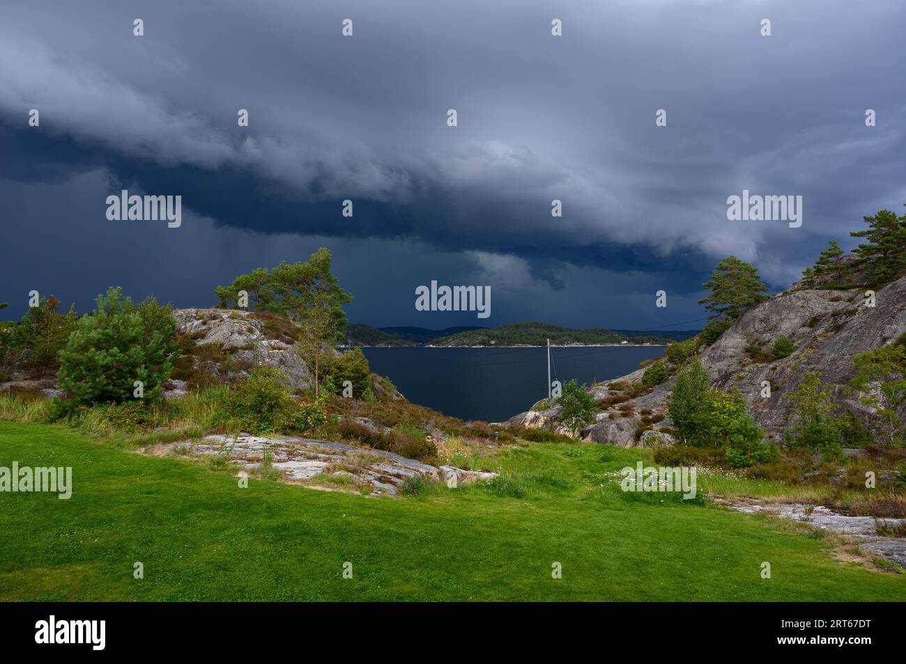 Des nuages de tempête spectaculaires s'accumulent au-dessus du rivage et se déplacent vers les îles de l'archipel de Kragero un jour d'été en août. Telemark, Norvège. Banque D'Images