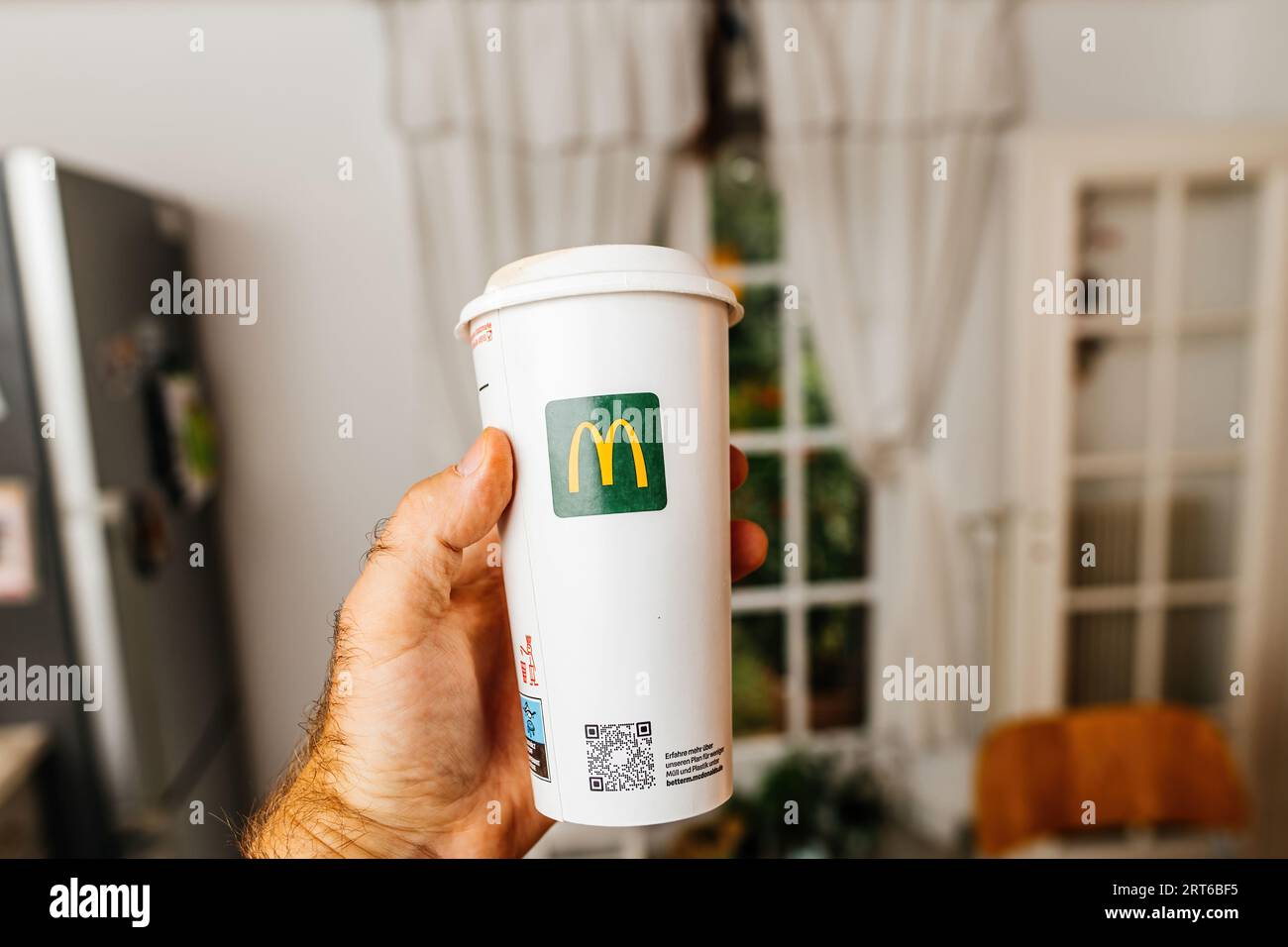 Paris, France - 4 août 2023 : main masculine POV : tenir un gobelet en  plastique McDonald's allemand avec logotype rouge au milieu d'un fond de  cuisine Photo Stock - Alamy