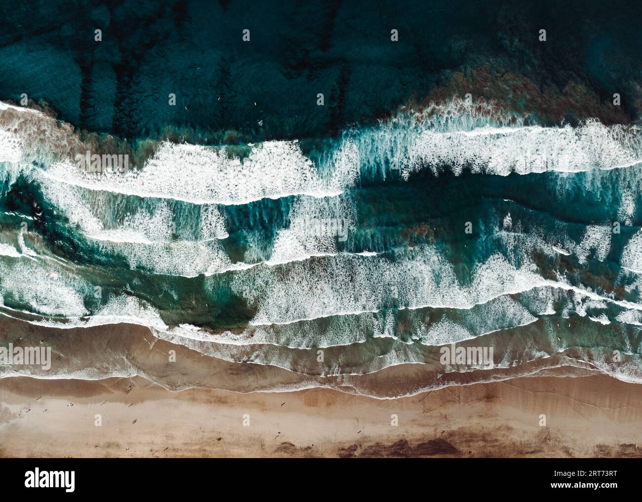 Vue de dessus par drone de plage de sable jaune avec océan et vagues. Plage avec beaucoup de surfeurs et de gens sur la journée ensoleillée d'en haut. Banque D'Images