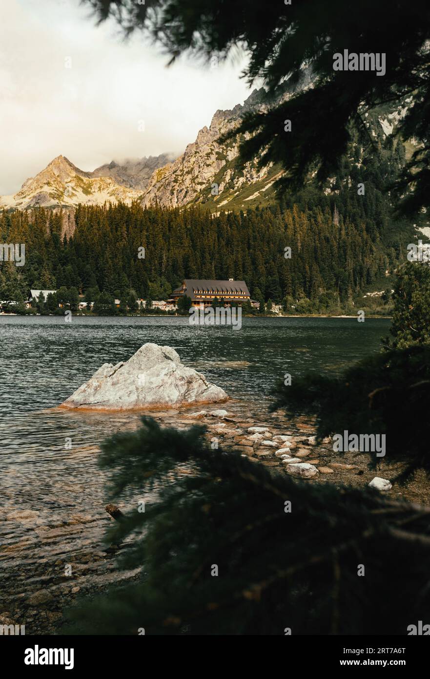 Photo de beau lac avec de l'eau cristalline situé dans les Hautes Tatras - Slovaquie. Plan vertical de Popradske pleso avec d'énormes montagnes et la forêt o Banque D'Images
