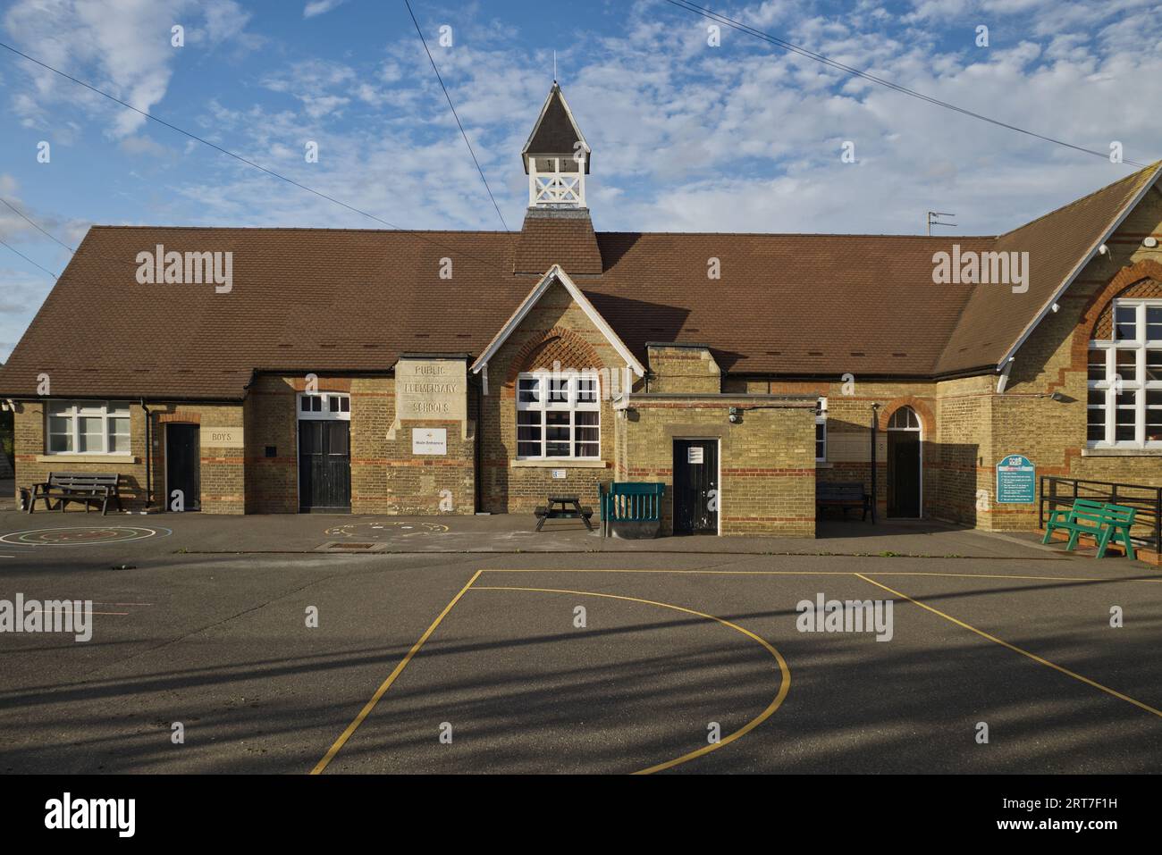 Sharnbrook High Street, Bedfordshire, Angleterre, Royaume-Uni, été - le terrain de jeu et les bâtiments victoriens de l'école primaire du village de Sharnbrook Banque D'Images