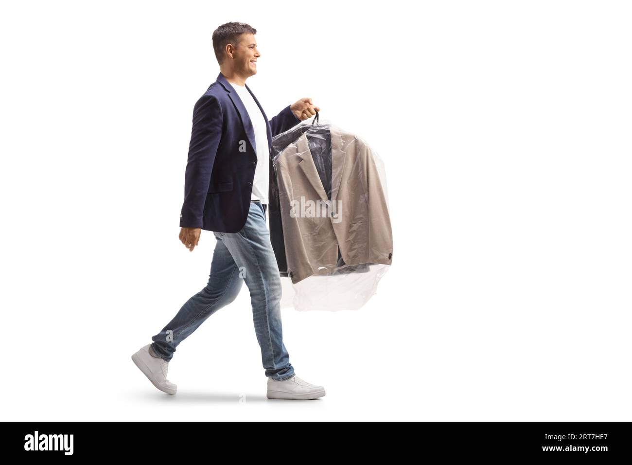 Photo de profil pleine longueur d'un homme portant une combinaison sur un cintre avec un sac de nettoyage à sec en plastique isolé sur un fond blanc Banque D'Images