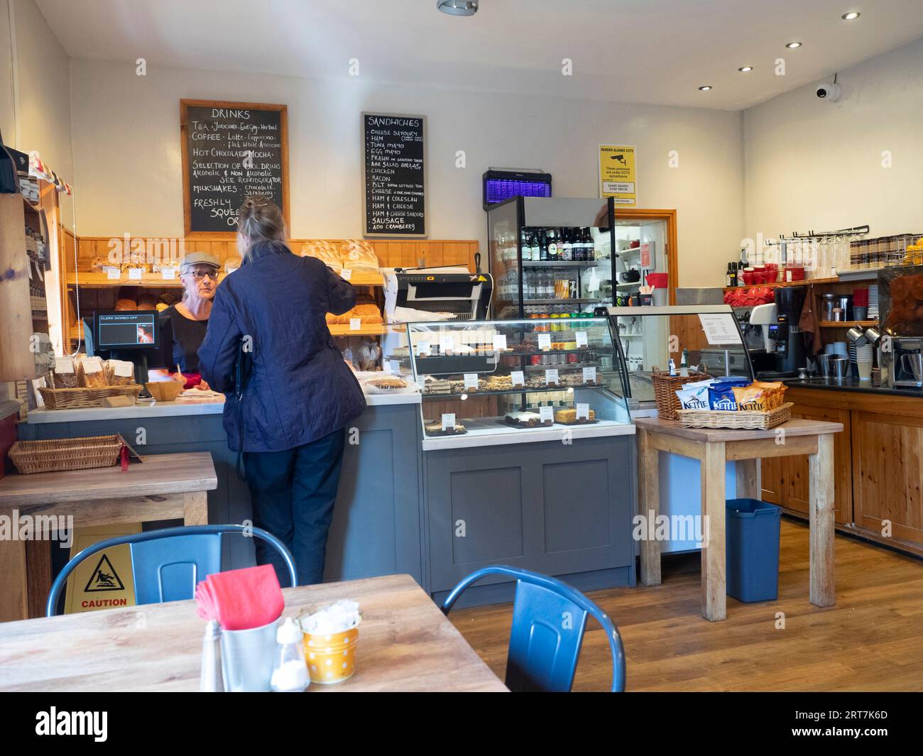 Intérieur de Danby Bakery et salon de thé à Danby North Yorkshire, avec une dame âgée achetant au comptoir les prix de septembre 2023 Banque D'Images