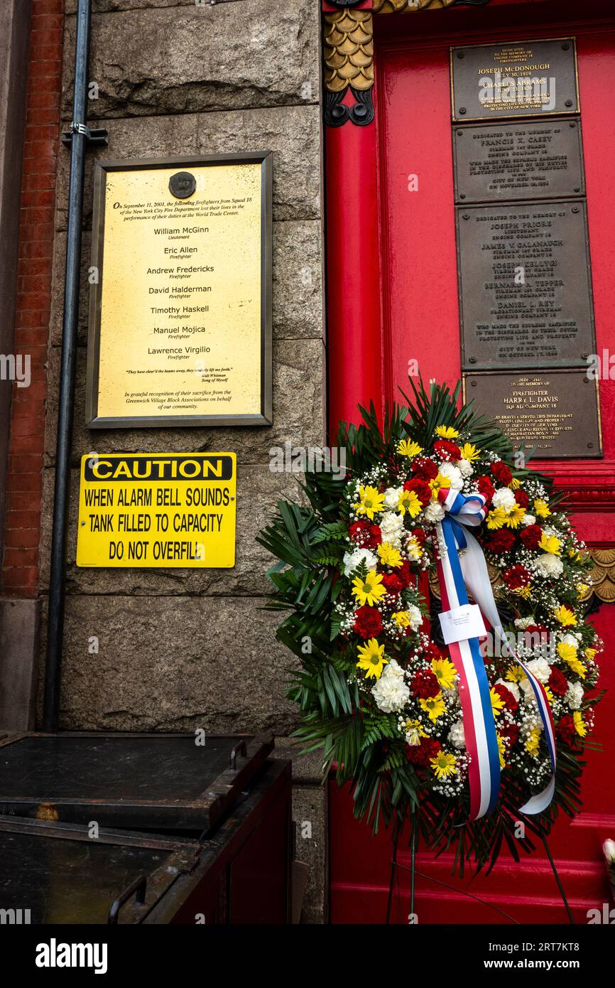 Souvenir de 9/11 avec des fleurs devant la liste des pompiers perdus sur 9/11 Squad 18 caserne de pompiers sur 10th St, Greenwich Village, New York City, NY Banque D'Images