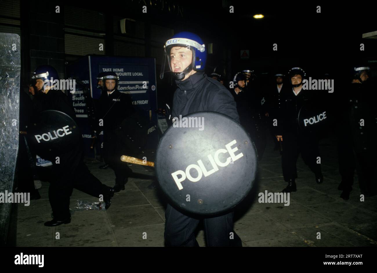 Brixton Riot avril 1985 Londres Polce charge avec bouclier anti-émeute. Brixton Sud Londres avril 1980s Angleterre HOMER SYKES. Banque D'Images
