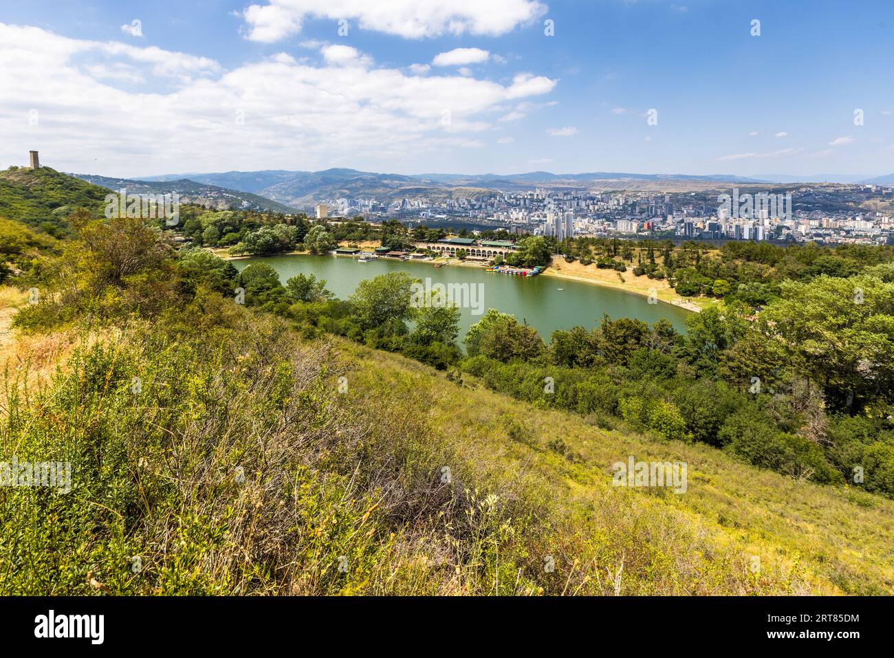 Un lac est situé à Vake, Tbilissi. La ville de Tbilissi est en arrière-plan. Une tour se dresse sur une colline Banque D'Images