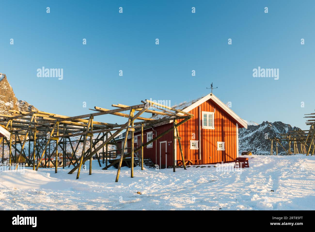 Cabane de pêche traditionnelle rouge à la corbu rénovée avec casiers vides pour Séchage de la morue sur les îles Lofoten en Norvège en hiver Banque D'Images