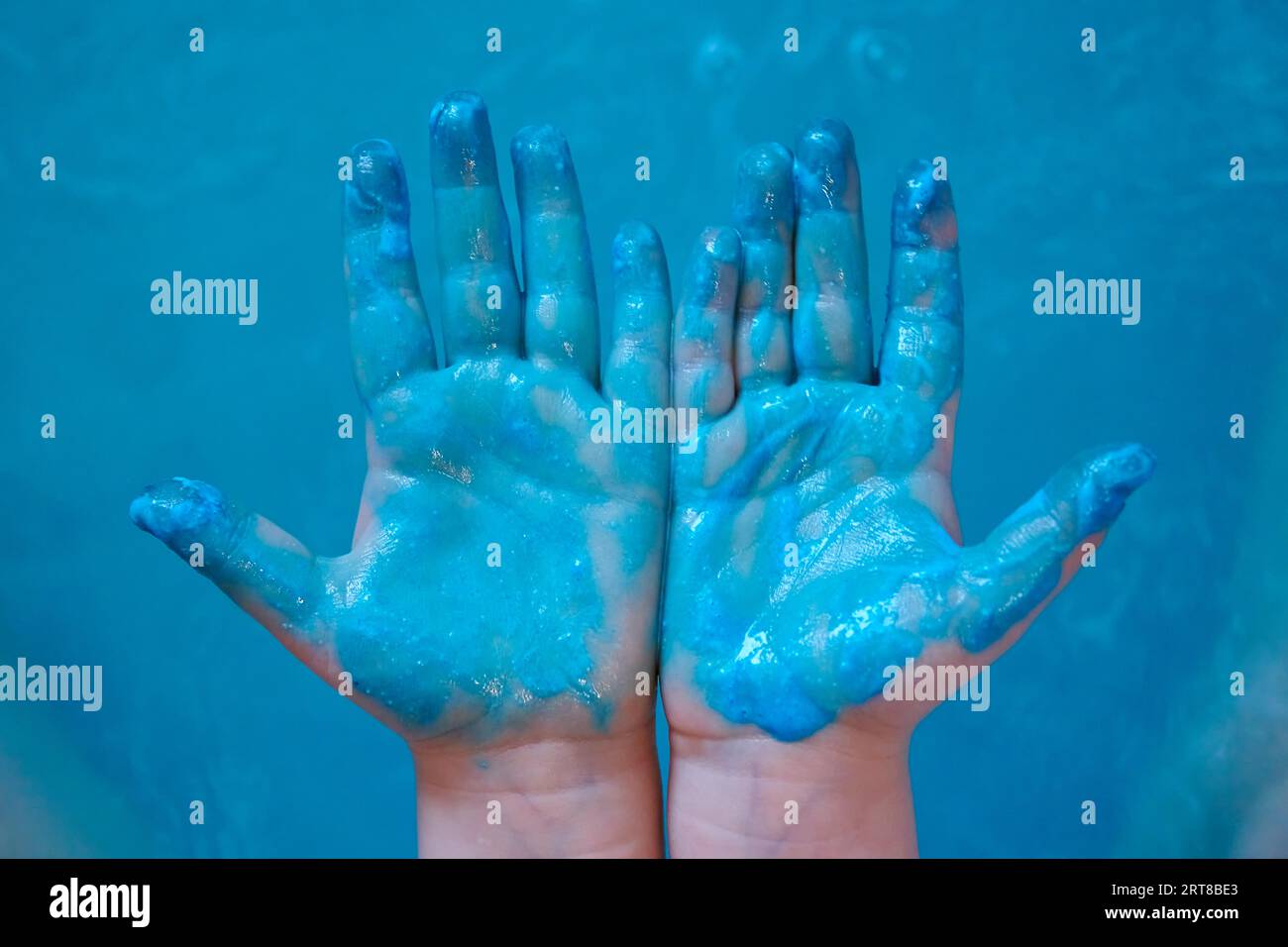Peinture bleue sur les mains bleues des enfants Banque D'Images