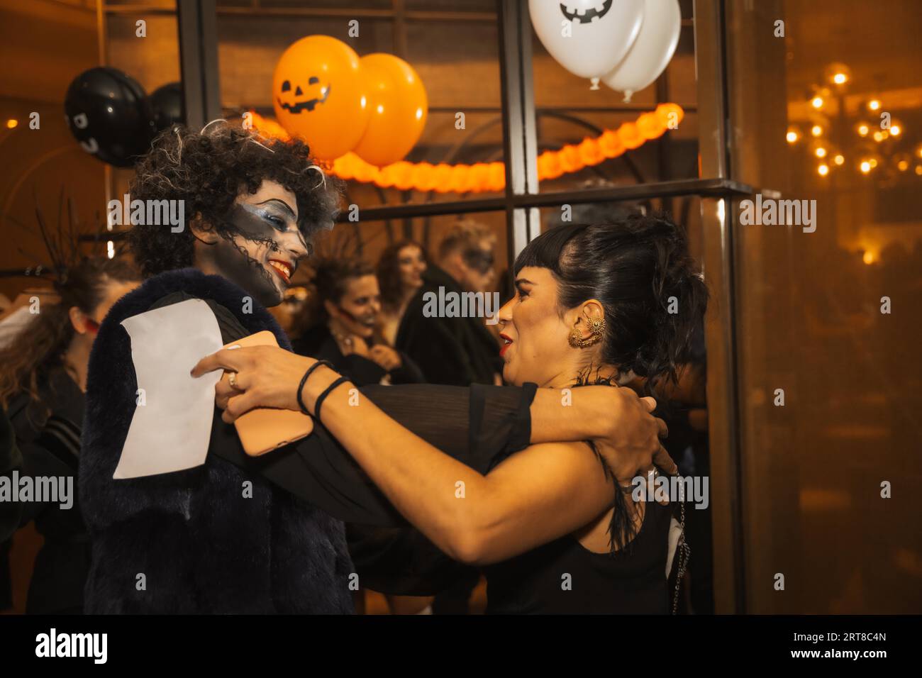 Fête d'Halloween avec des amis dans une discothèque, deux amis se saluent à la fête Banque D'Images