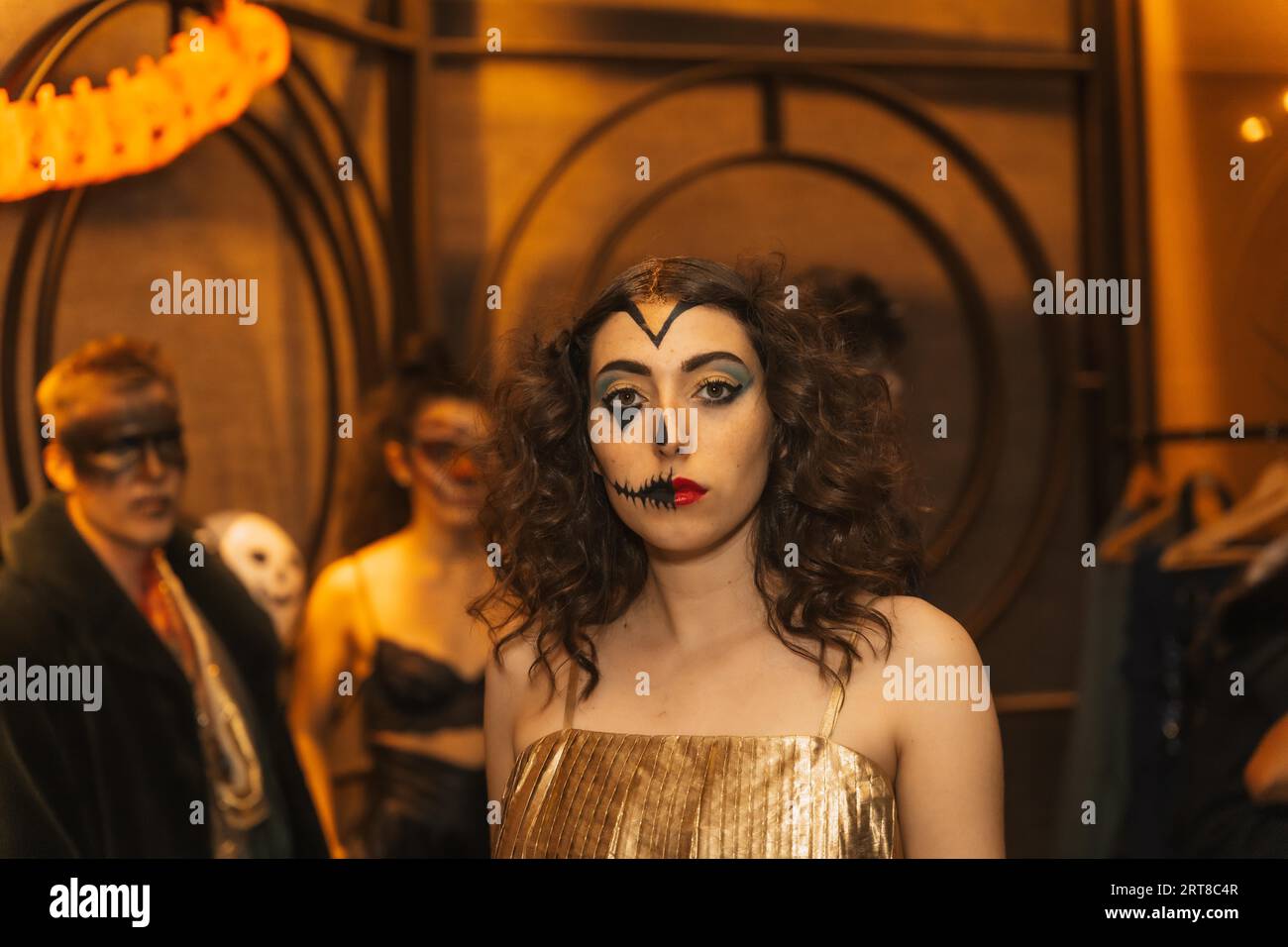 Fête d'Halloween avec des amis dans une discothèque, portrait d'une femme en costume avec lit peint Banque D'Images