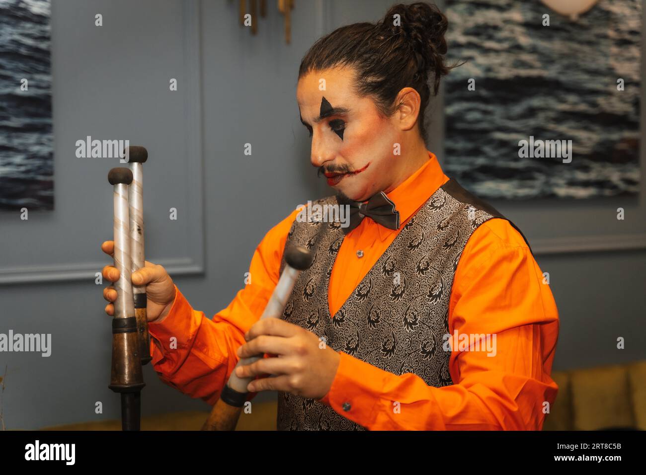 Jongleur à une fête d'halloween jonglant des bâtons avec du feu, préparant de l'essence Banque D'Images