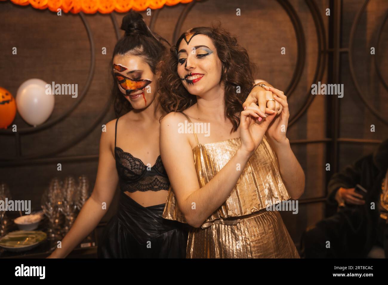 Portrait amies féminines s'amusant à la fête d'halloween avec des amis dans la discothèque Banque D'Images