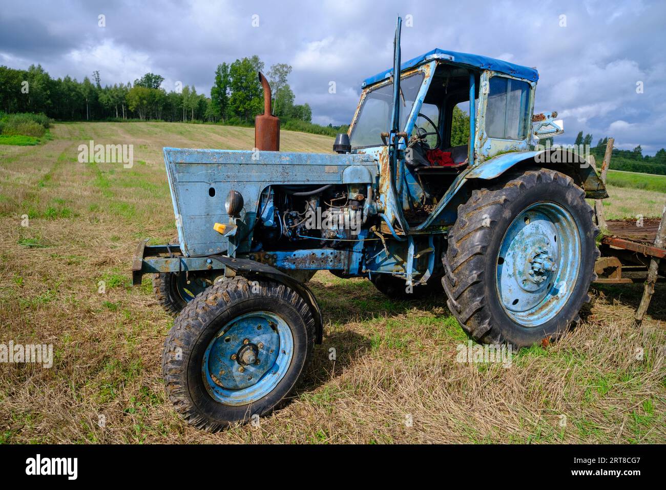 Vieux tracteurs agricoles russes bleus dans le champ. Machines agricoles dans la ferme. Équipement agricole spécial. Machine agricole durable Banque D'Images