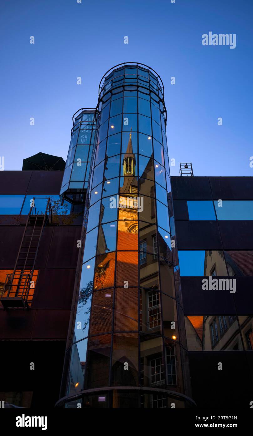La tour sud de la collégiale et le Fruchtkasten se reflètent dans la façade moderne en verre d'un nouveau bâtiment, heure bleue, Stuttgart Banque D'Images
