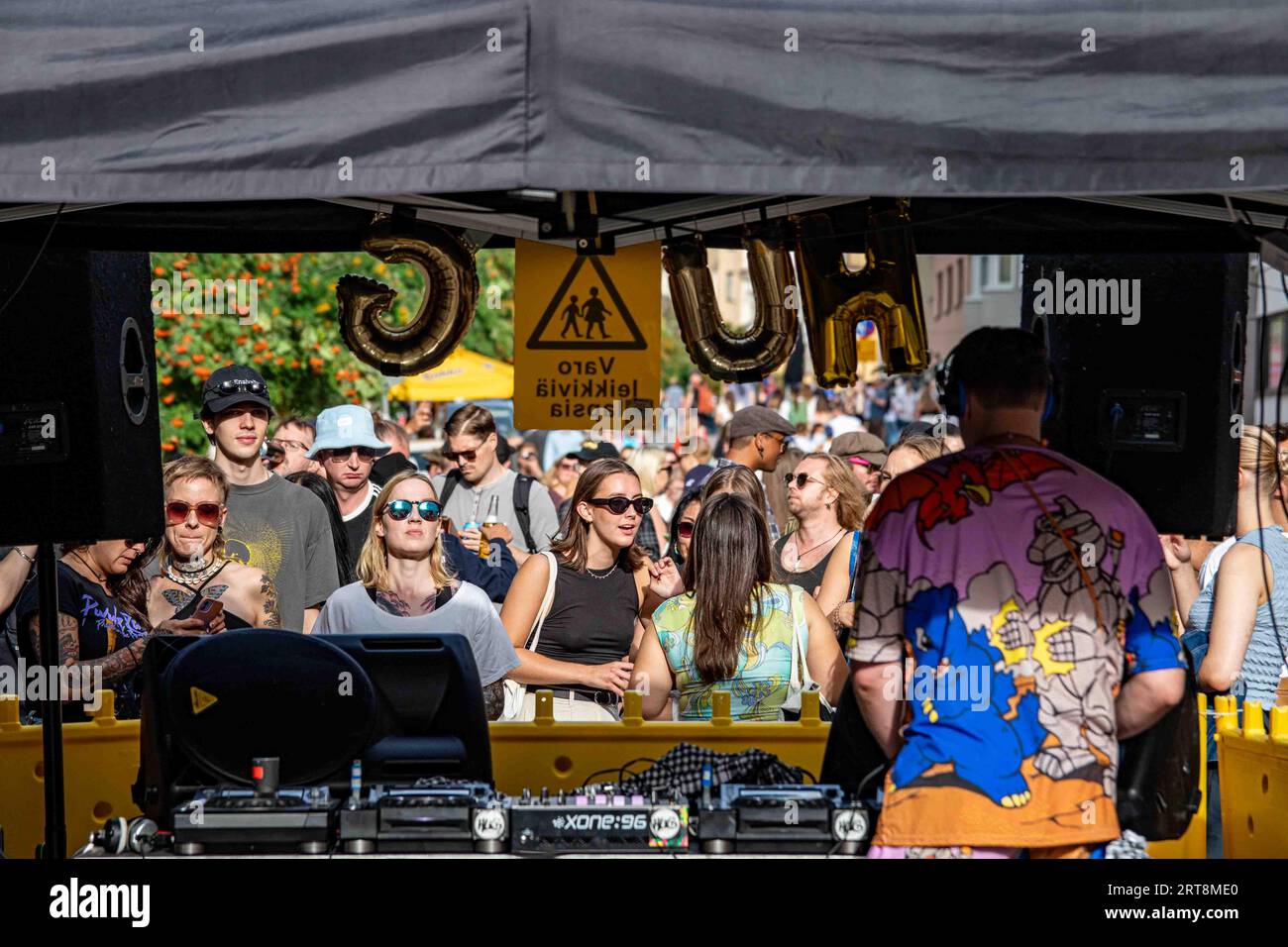 Des jeunes écoutant de la musique devant une cabine DJ extérieure lors d’une journée ensoleillée d’été à Kallio Block Party 2023 à Helsinki, Finlande Banque D'Images