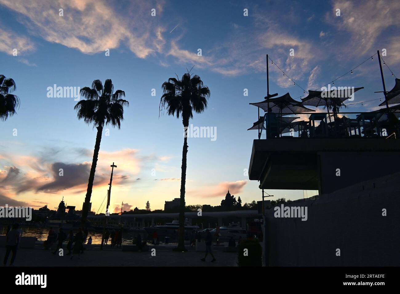 Bar au coucher du soleil sur la promenade du port, Malaga, Andalousie, Espagne Banque D'Images