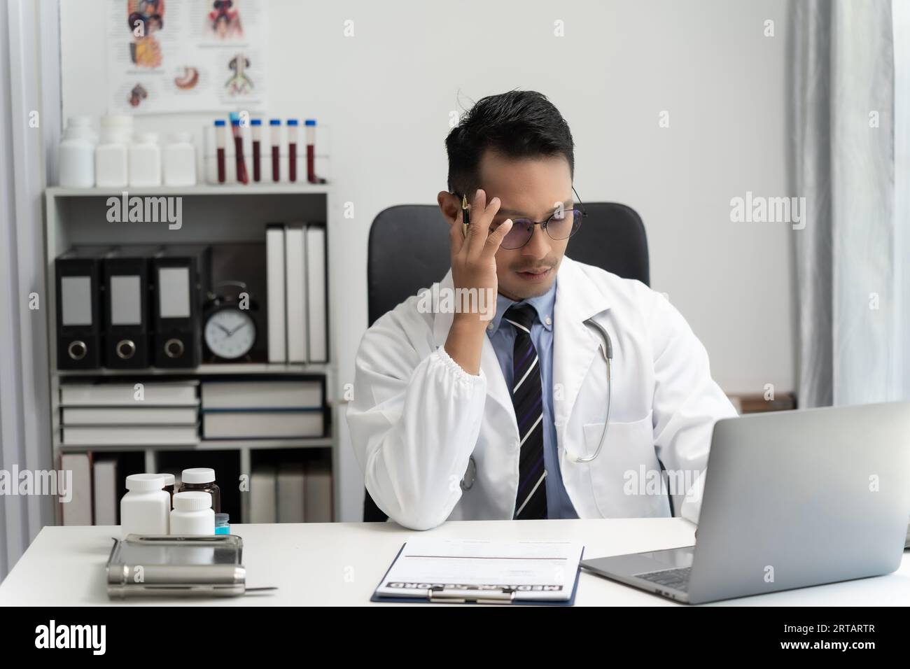 Homme asiatique sourire médecin penser et les patients utilisent l'ordinateur pour expliquer le travailleur médical ou la consultation dans la conférence téléphonique de l'hôpital, les soins de santé de télémédecine Banque D'Images
