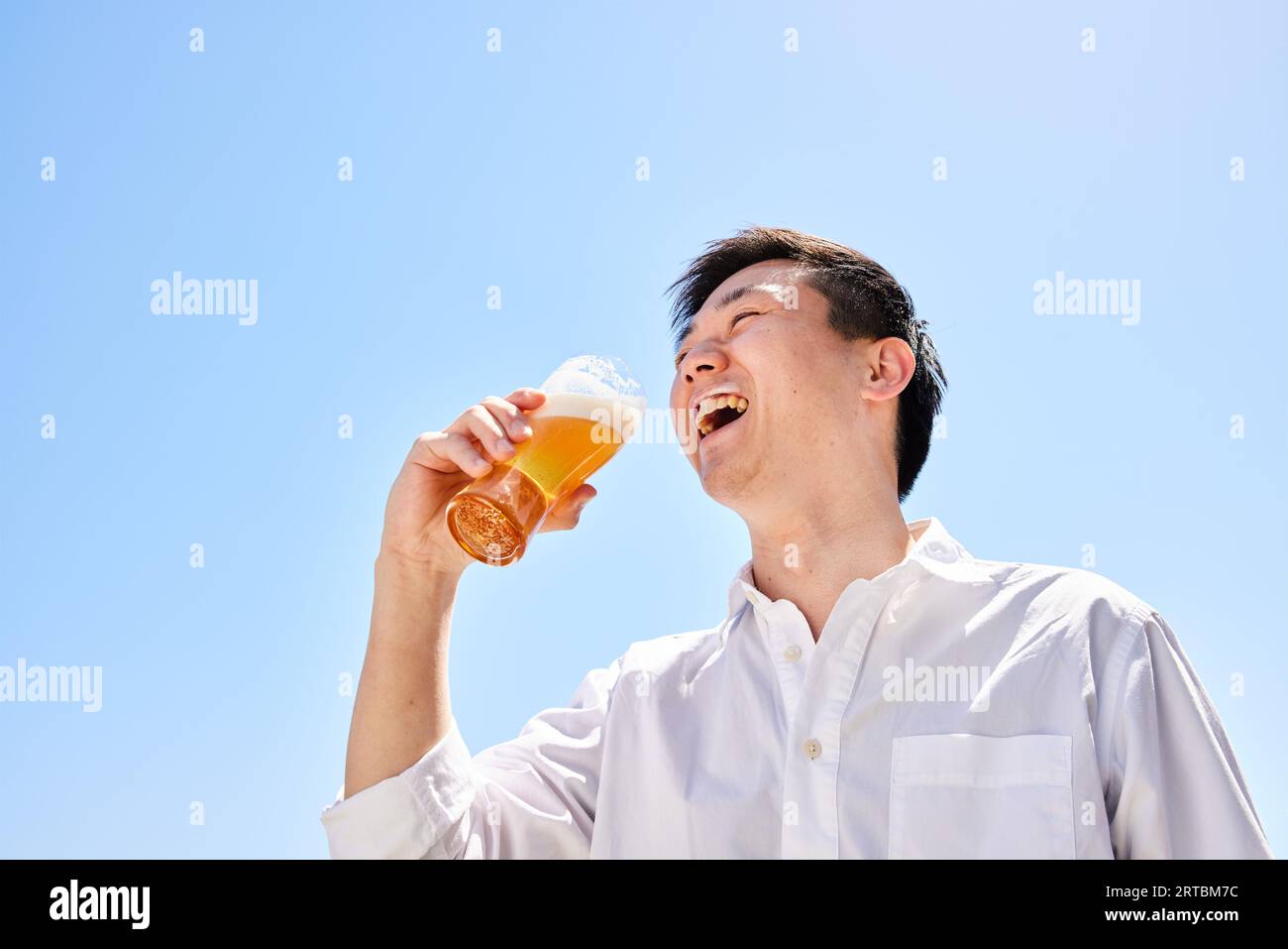 Homme japonais buvant de la bière Banque D'Images