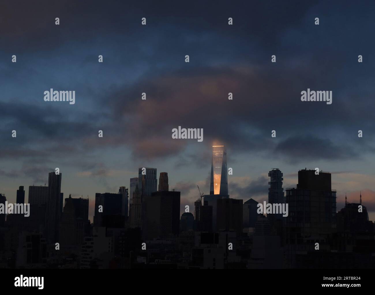 New York, États-Unis. 11 septembre 2023. La lumière du soleil est réfléchie par One World Trade Center qui est partiellement obstrué par des nuages bas après le lever du soleil à New York le mardi 12 septembre 2023. Photo de John Angelillo/UPI crédit : UPI/Alamy Live News Banque D'Images