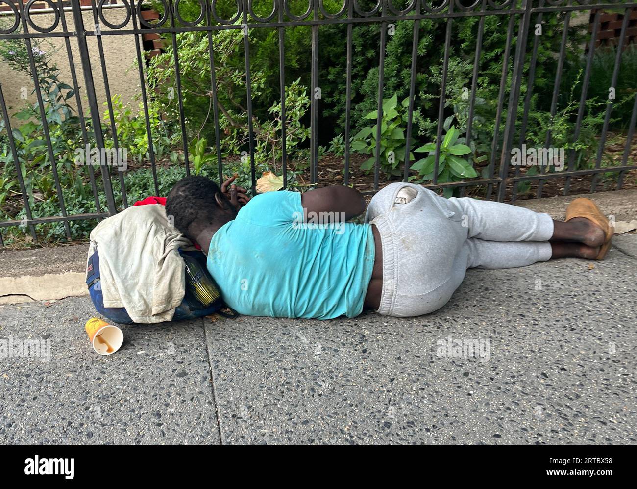 Un sans-abri dort sur un trottoir dans le quartier résidentiel de Park Slope à Brooklyn, New York. Banque D'Images