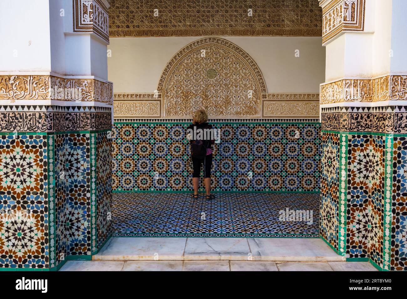 Afrique du Nord. Maroc. Marrakech. Madrasa Ben Youssef. La madrassah la plus grande et la plus importante du Maroc. Femme touriste regarde l'écriture coranique Banque D'Images