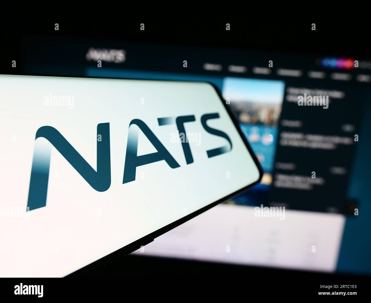 Téléphone portable avec le logo de l'opérateur britannique de contrôle du trafic aérien NATS Limited sur l'écran en face du site Web. Concentrez-vous sur le centre gauche de l'écran du téléphone. Banque D'Images