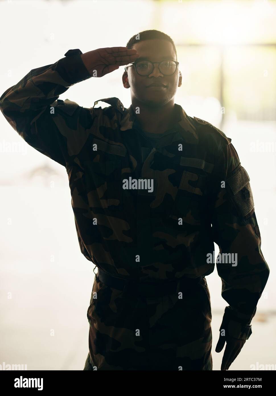 Portrait de soldat confiant, armée et salut dans la construction avec fierté, héros professionnel et service de nuit. Carrière militaire, sécurité et courage, noir Banque D'Images