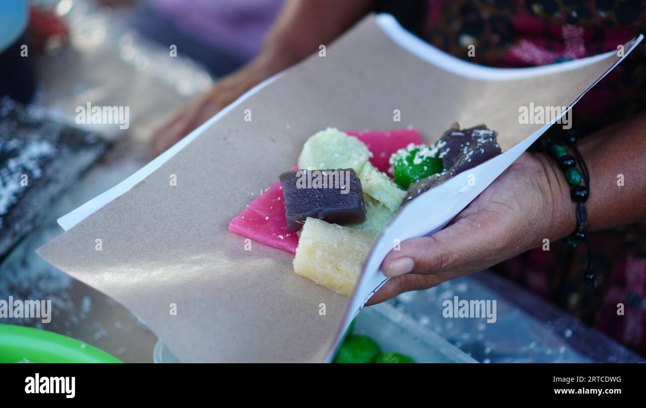 Le cenil, un gâteau javanais traditionnel à base d'amidon de manioc, formé et coloré de diverses sortes servi dans des récipients en papier et mélangé avec de la noix de coco râpée Banque D'Images