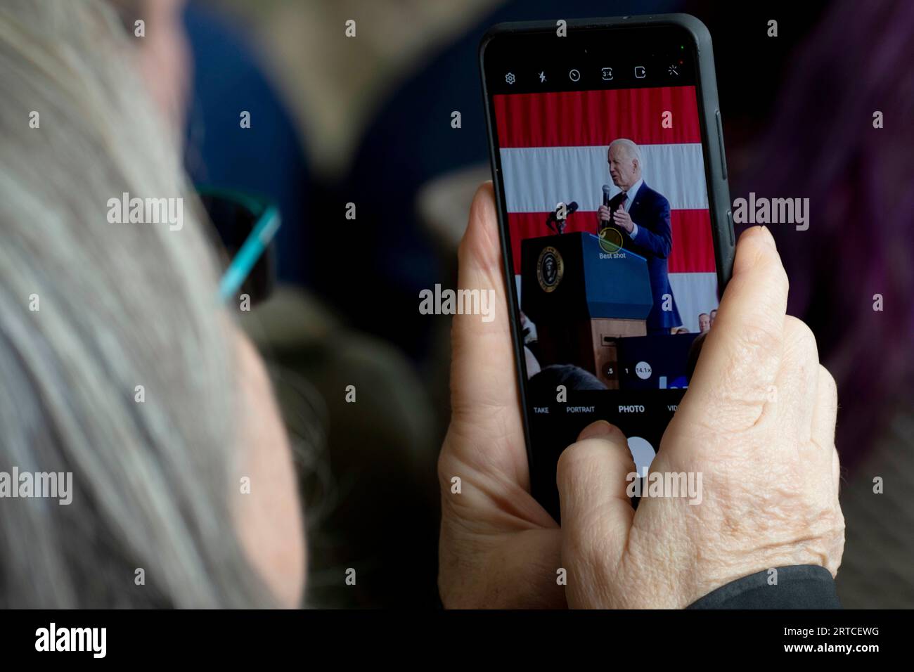 Anchorage (États-Unis d ' Amérique). 11 septembre 2023. Anchorage (États-Unis d ' Amérique). 11 septembre 2023. Un membre du public prend une photo de téléphone portable du président américain Joe Biden alors qu'il prononce un discours commémorant le 22e anniversaire des attaques terroristes de 9/11 à la base interarmées Elmendorf-Richardson, le 11 septembre 2023 à Anchorage, Alaska. Crédit : Sheila deVera/États-Unis Air Force photo/Alamy Live News Banque D'Images
