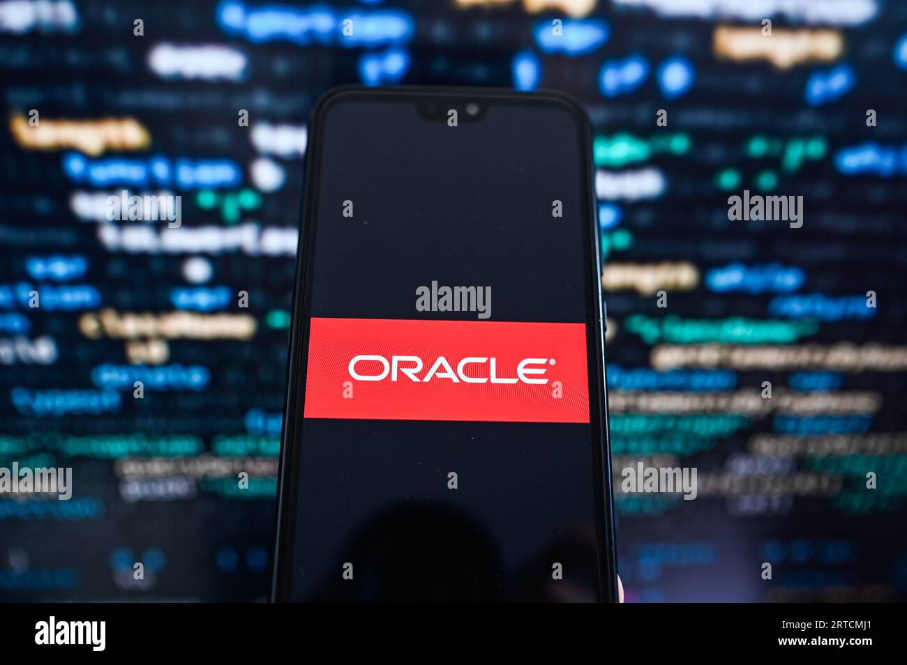 Sur cette photo, un logo Oracle affiché sur un smartphone avec un code de programmation en arrière-plan. Banque D'Images
