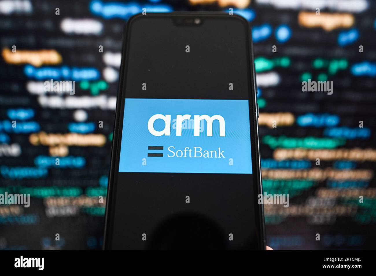 Dans cette illustration photo, un logo ARM affiché sur un smartphone avec un code de programmation en arrière-plan. Banque D'Images