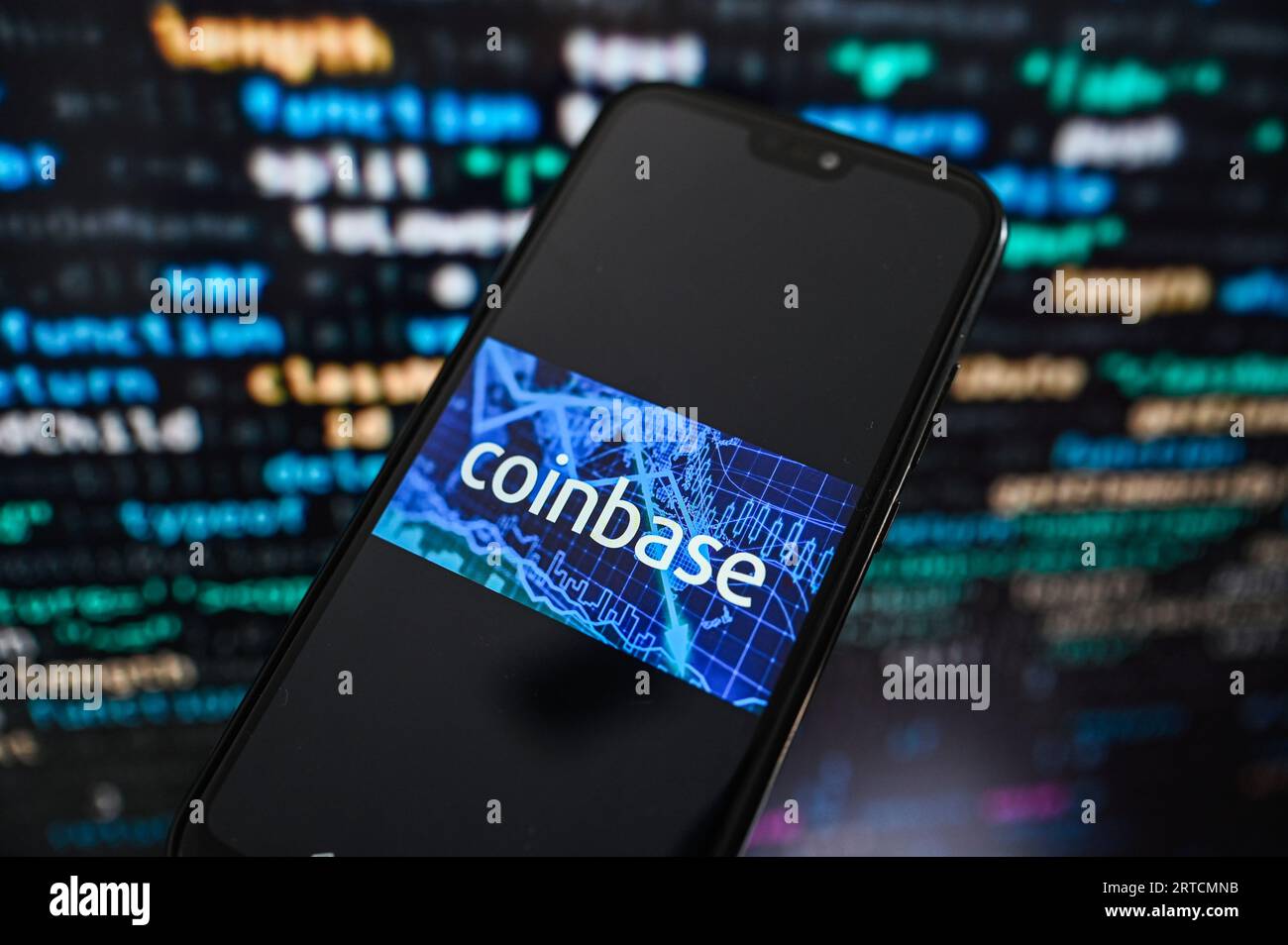 Dans cette illustration photo, un logo Coinbase affiché sur un smartphone avec code de programmation en arrière-plan. Banque D'Images