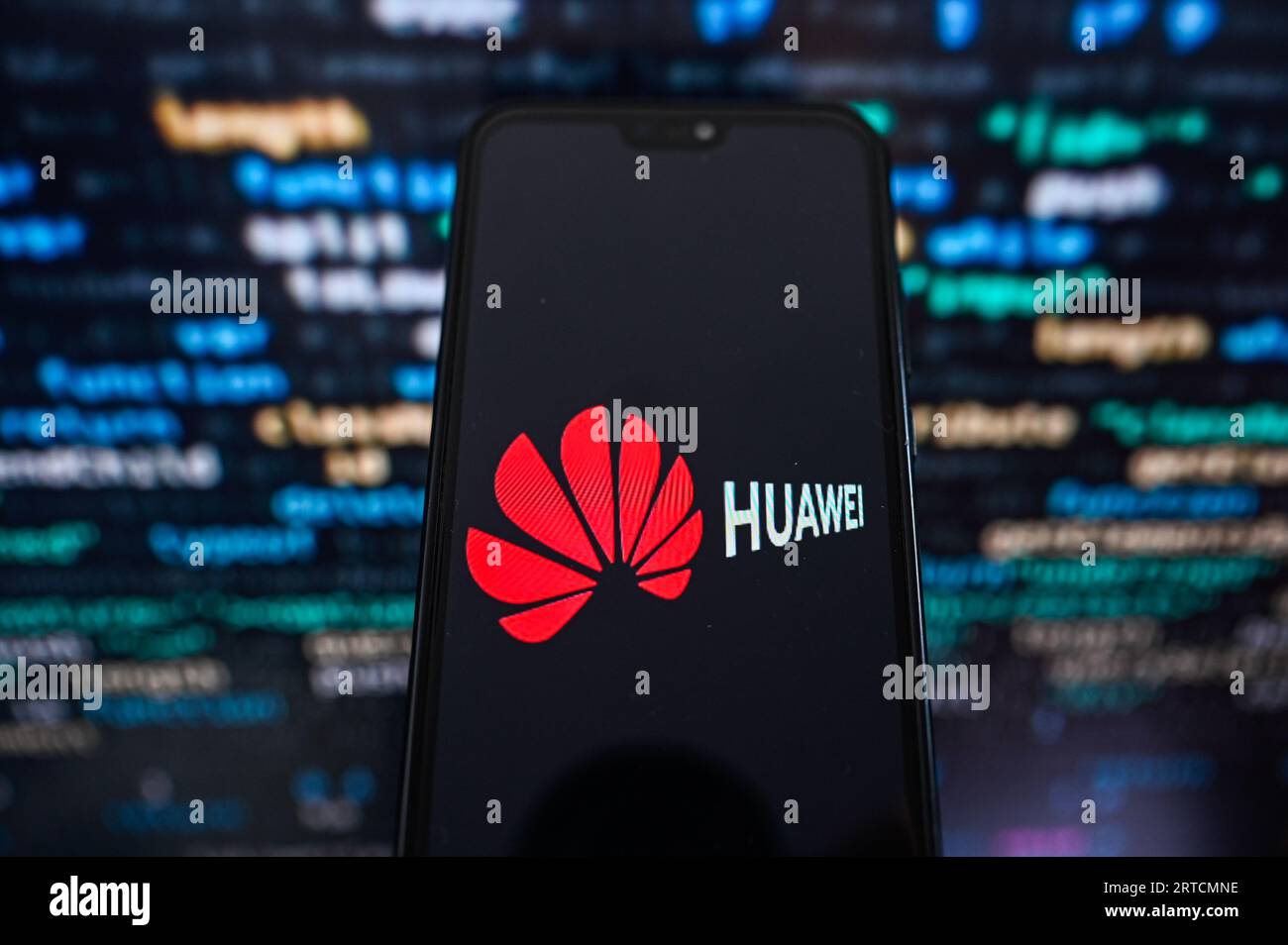 Dans cette illustration photo, un logo Huawei affiché sur un smartphone avec code de programmation en arrière-plan. Banque D'Images