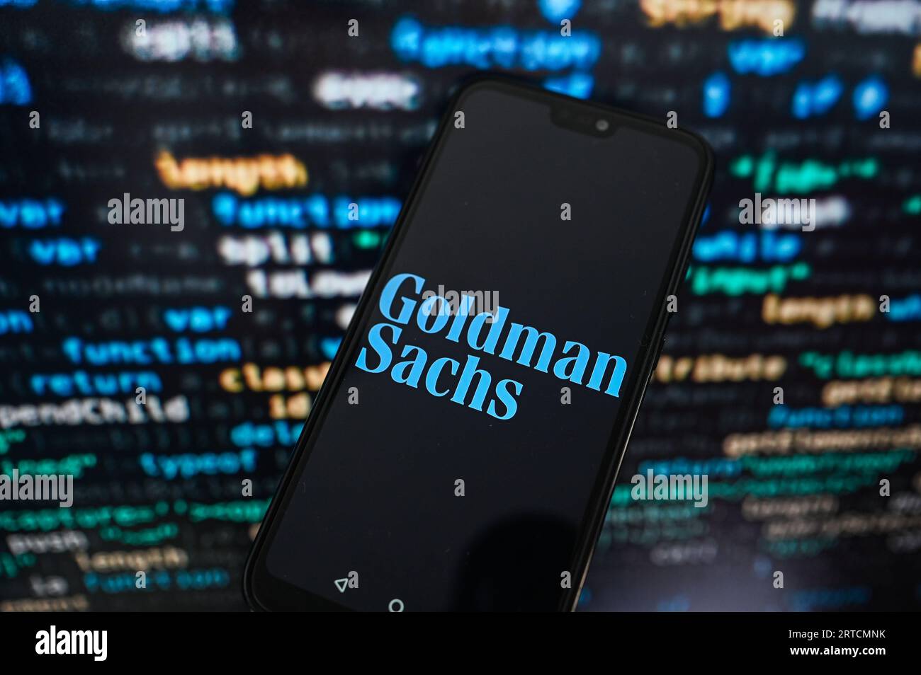 Sur cette photo, un logo Goldman Sachs affiché sur un smartphone avec code de programmation sur le fond. Banque D'Images