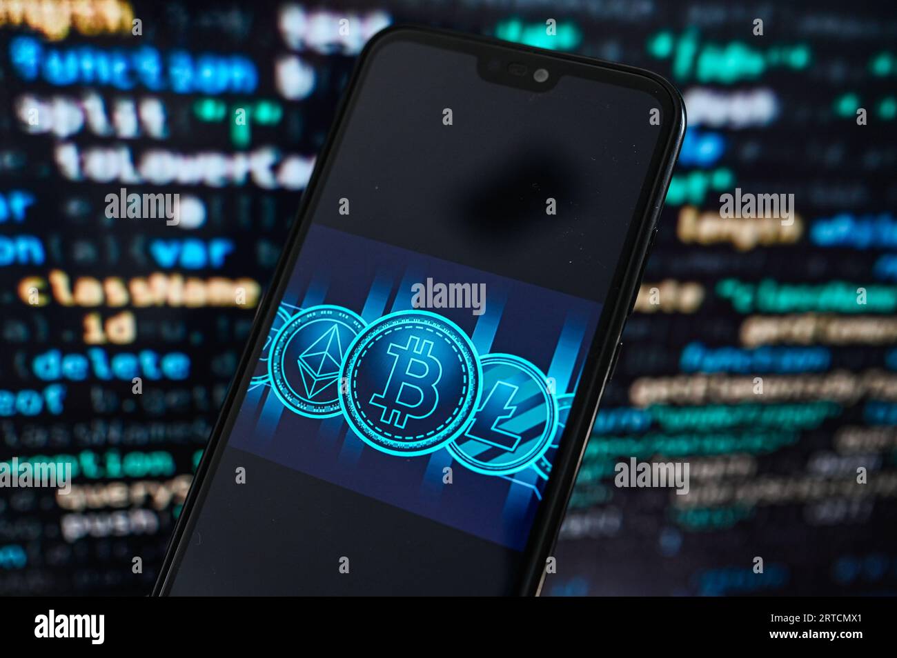 Dans cette illustration photo, un logo Crypto devises est affiché sur un smartphone avec le code de programmation sur le fond. Banque D'Images