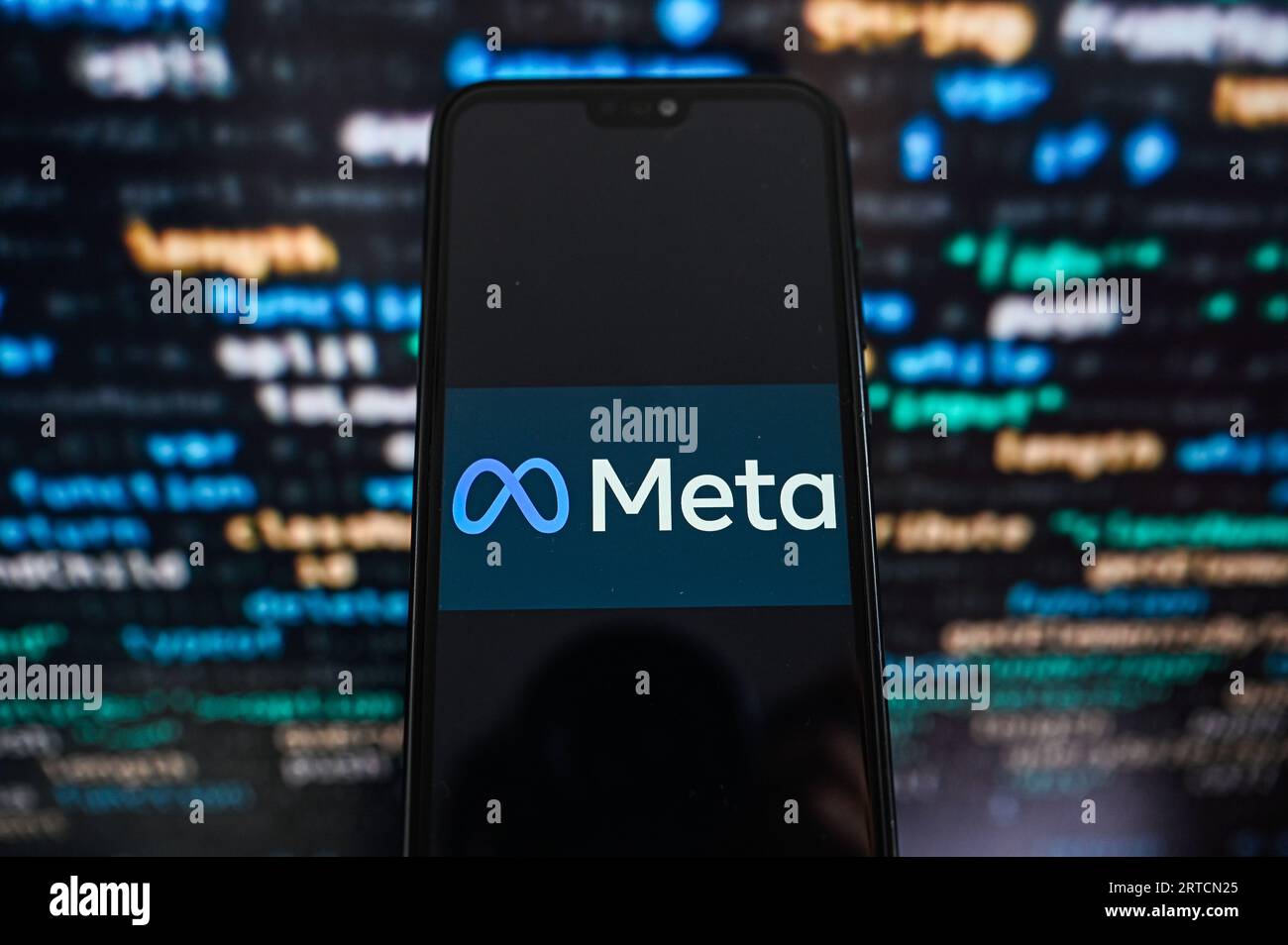 Dans cette illustration photo, un MÉTA logo affiché sur un smartphone avec code de programmation sur le fond. Banque D'Images
