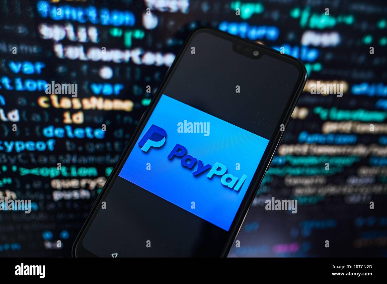 Dans cette illustration photo un logo Paypal affiché sur un smartphone avec code de programmation sur le fond. Banque D'Images