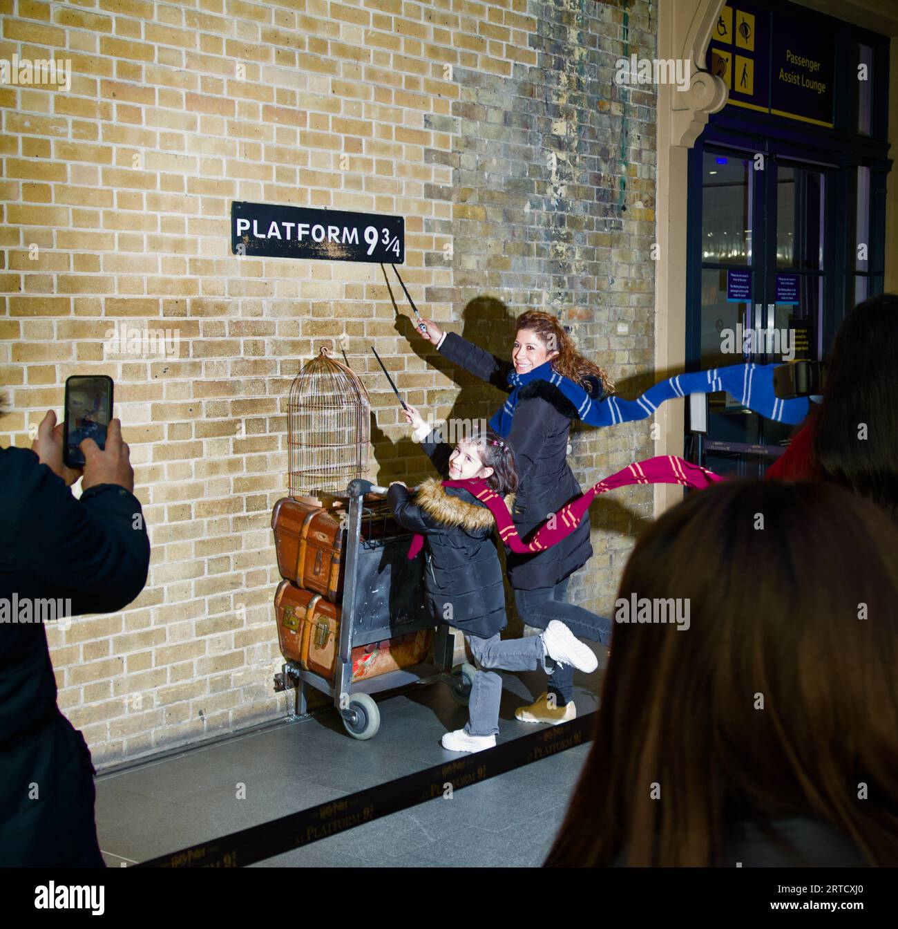 Mère et fille ayant leur photographie prise à Harry Potters Platform 9 3/4, Kings Cross Station, Londres Royaume-Uni Banque D'Images