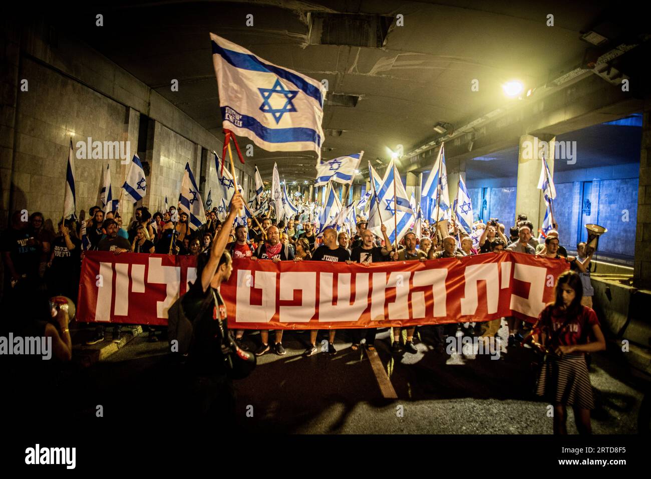 Jérusalem, Israël. 11 septembre 2023. Des manifestants défilent en brandissant des drapeaux israéliens et une banderole qui dit en hébreu "la cour est suprême" lors d'une manifestation à Jérusalem. Des milliers de manifestants anti-gouvernementaux israéliens se sont rassemblés devant la Cour suprême lundi, à la veille d'une audience historique sur une tentative de la coalition du Premier ministre Benjamin Netanyahu de restreindre les pouvoirs de la Cour. Crédit : SOPA Images Limited/Alamy Live News Banque D'Images