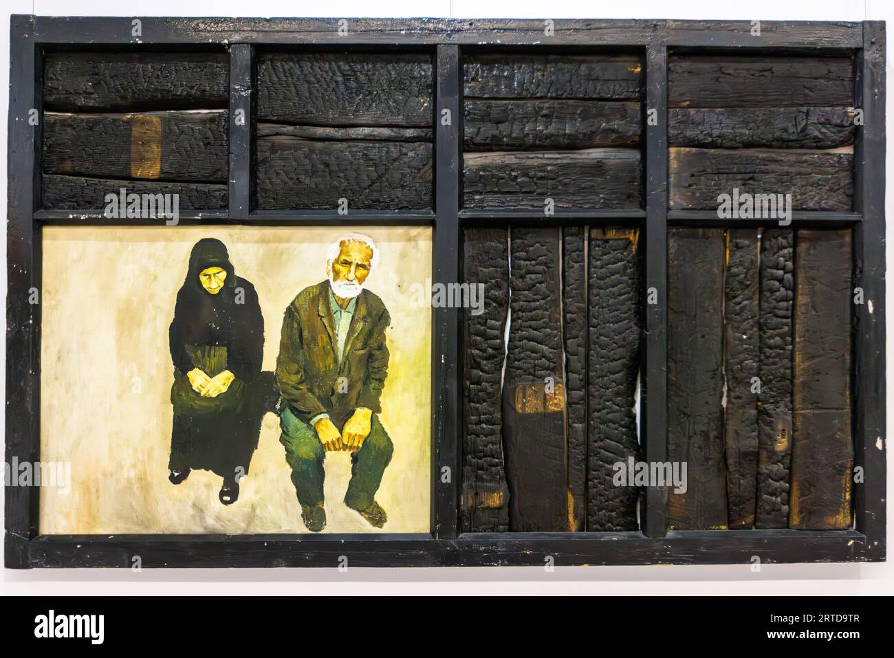 Une peinture montre une femme âgée et un homme plus âgé. Il est placé dans un cadre en bois carbonisé. Le cadre contient d'autres compartiments avec des morceaux de bois carbonisé. L'œuvre est conservée au Simon Janashia National Museum of Georgia à Tbilissi, Géorgie Banque D'Images