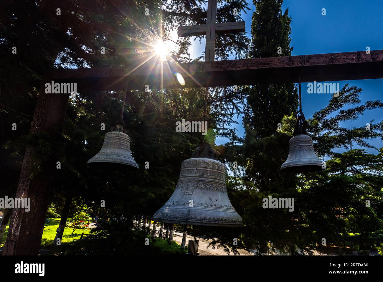 Trois cloches d'église pendent devant l'église Metekhi de la Nativité de la mère de Dieu à Tbilissi, suspendues à un cadre de cloche en bois surmonté d'une croix. Dans la tradition orthodoxe géorgienne, les cloches ne sont souvent pas situées dans la tour de l'église, mais sur un cadre indépendant devant l'église ; l'église Metekhi se trouvait à l'origine au centre de la résidence royale médiévale sur la rive escarpée surplombant le Mtkvari. Metekhi Ascent, Zemo Avlabari, Metromsheni, district d'Isani, Tbilissi, 0144, Géorgie Banque D'Images