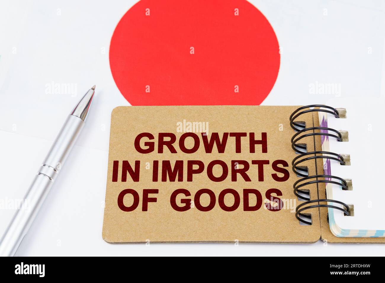 Concept d'économie et de finance. Sur le drapeau du Japon se trouve un stylo et un carnet avec l'inscription - croissance des importations de marchandises. Banque D'Images