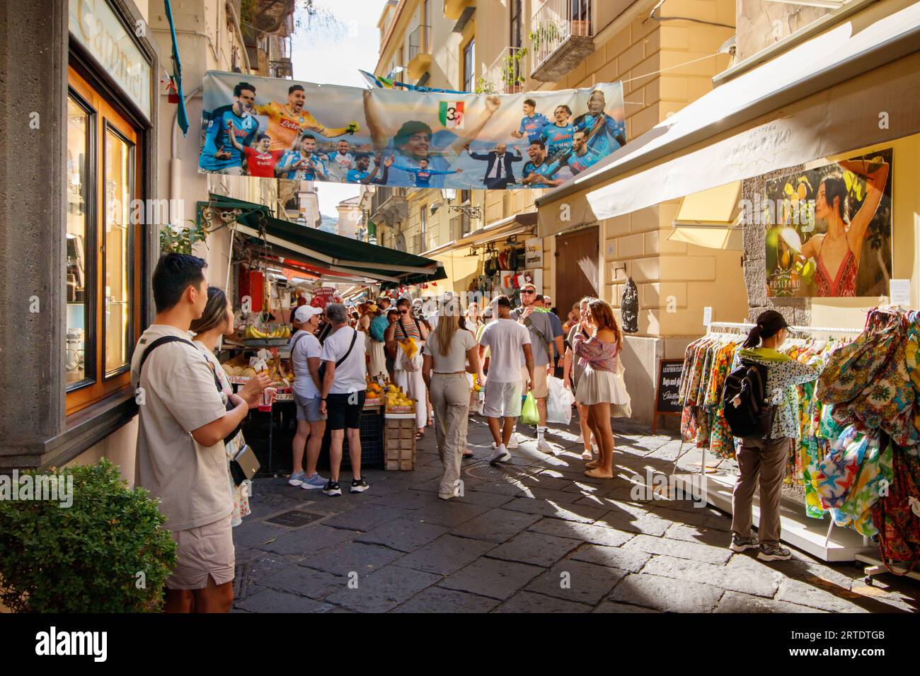 Via S Cesareo, une ruelle étroite bordée de boutiques touristiques en plein centre de Sorrente, en Italie. Sorrente est une ville côtière du sud-ouest de l'Italie, face à la baie de Naples sur la péninsule de Sorrente. Perché au sommet des falaises qui séparent la ville de ses ports de plaisance animés, il est connu pour ses vues panoramiques sur l'eau et la Piazza Tasso, une place bordée de cafés. Banque D'Images