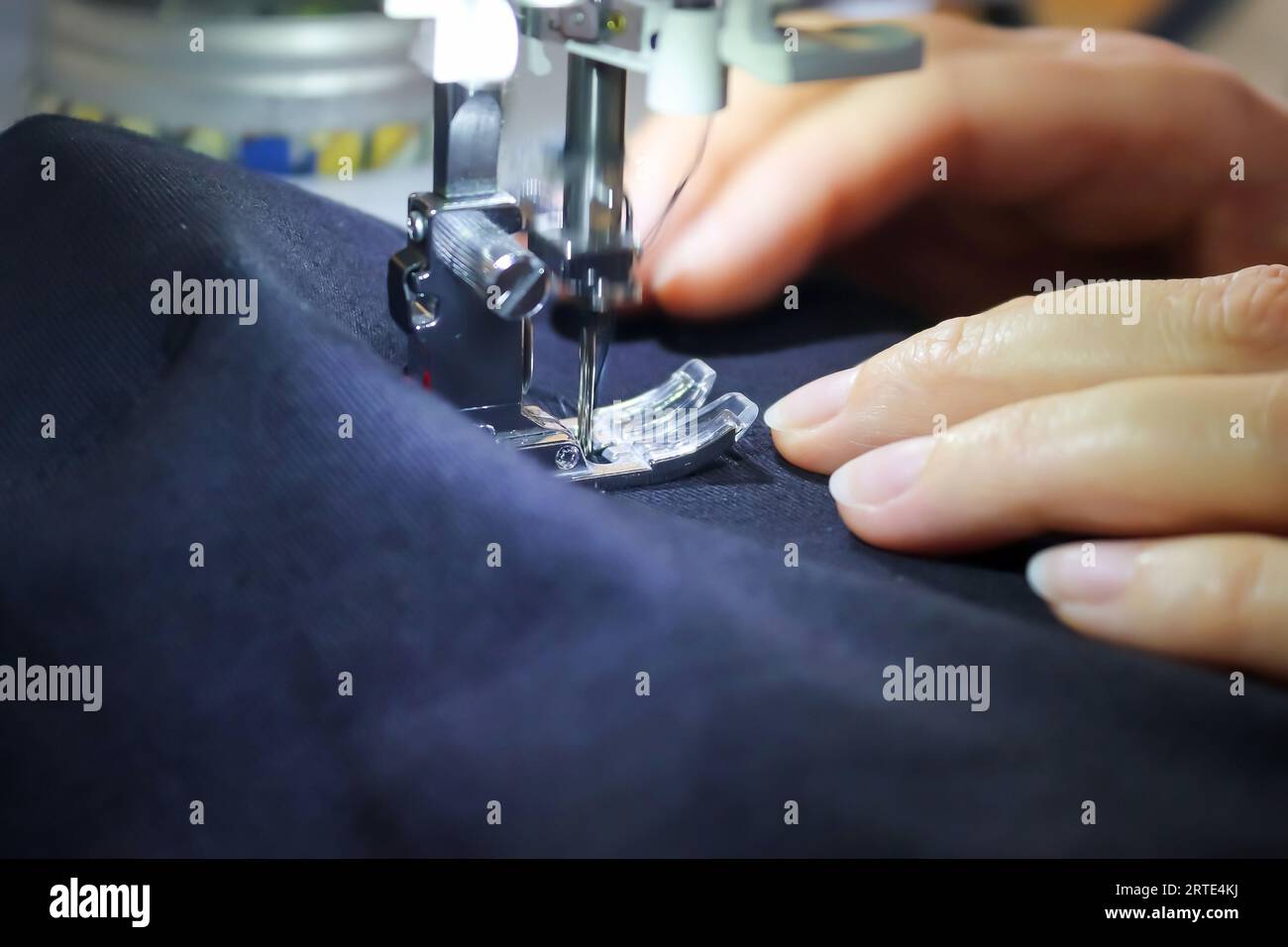 Mains féminines travaillant à Une machine à coudre moderne avec quelques tissus et textiles Banque D'Images