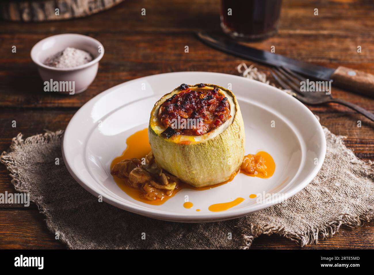 Portion de courgettes cuites au four farcies de viande hachée et d'herbes sur assiette Banque D'Images